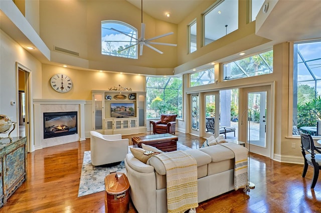 living room featuring ceiling fan, a high end fireplace, and hardwood / wood-style floors