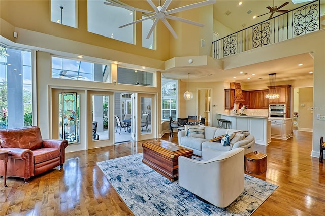 living room featuring ornamental molding, light wood-type flooring, and ceiling fan