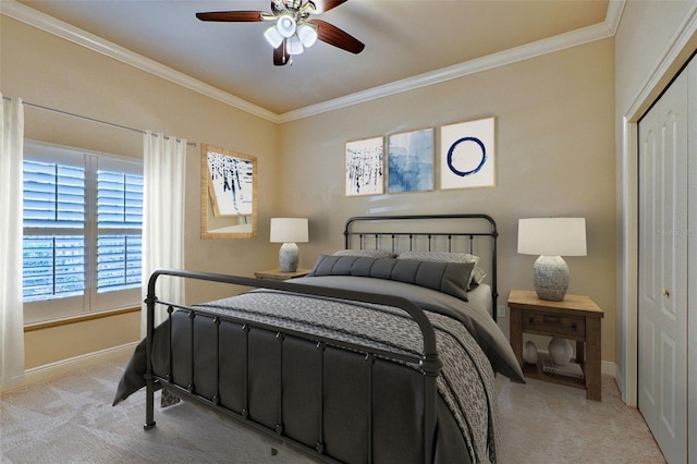 bedroom with crown molding, light colored carpet, ceiling fan, and a closet