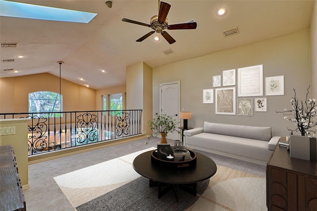 living room with ceiling fan, lofted ceiling with skylight, and light carpet