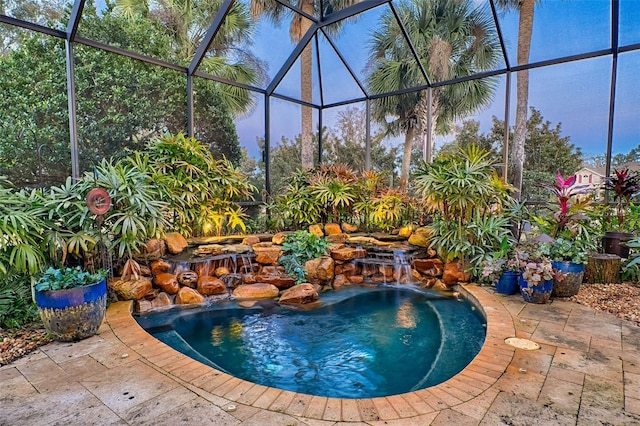 view of swimming pool featuring a patio, pool water feature, and glass enclosure