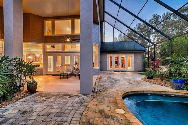 back of property with ceiling fan, a patio area, glass enclosure, and french doors