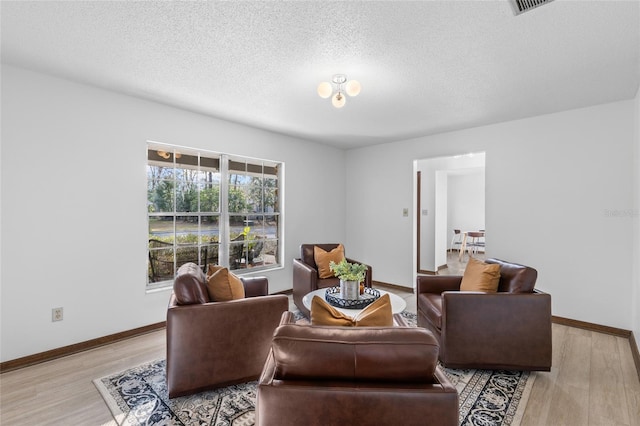 living room with light hardwood / wood-style floors and a textured ceiling