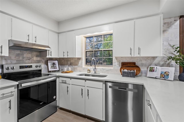 kitchen featuring sink, white cabinetry, a textured ceiling, stainless steel appliances, and decorative backsplash