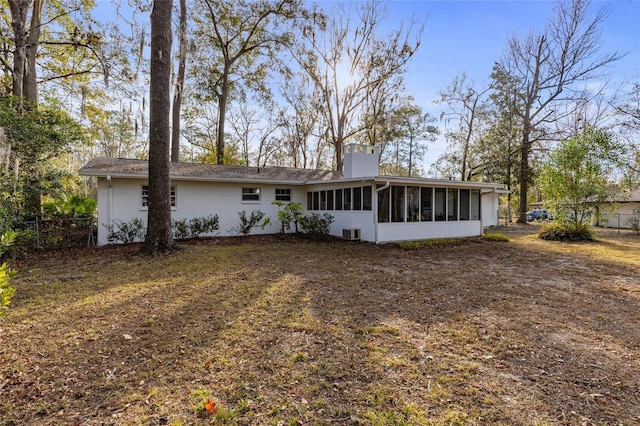 rear view of house featuring central AC and a sunroom