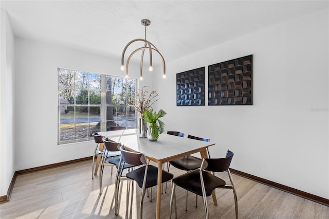 dining space featuring an inviting chandelier and light wood-type flooring