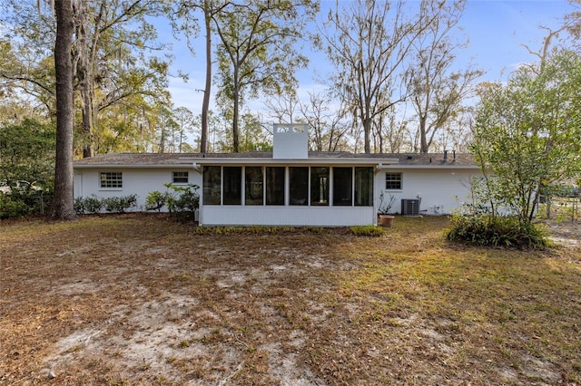 rear view of house with central AC and a sunroom