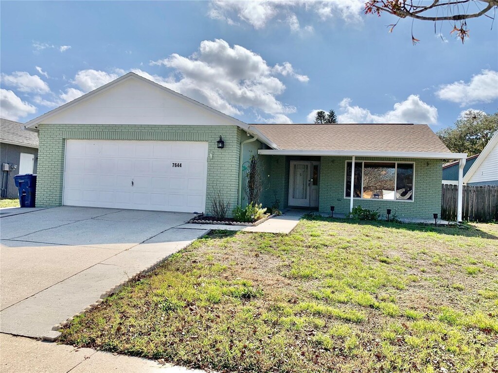 7644 Arlight Dr, New Port Richey, FL 34655 - ranch-style home featuring a garage and a front lawn