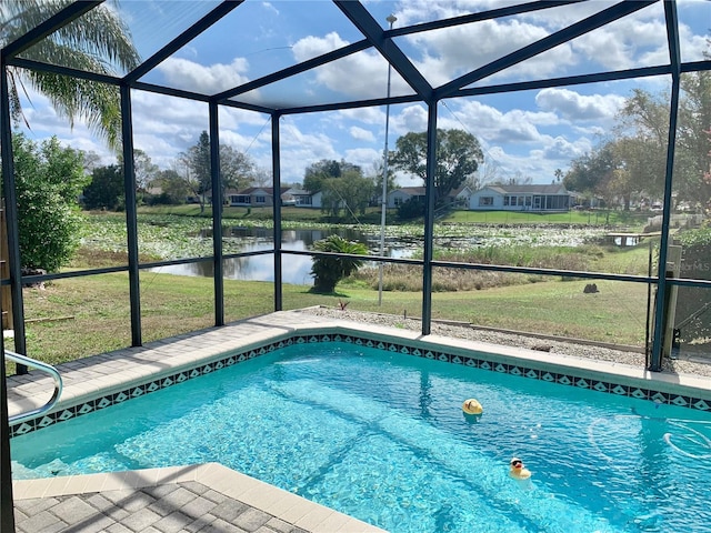 view of swimming pool featuring a water view, a yard, and glass enclosure