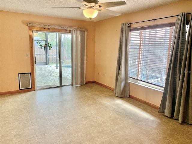 empty room with ceiling fan and a textured ceiling