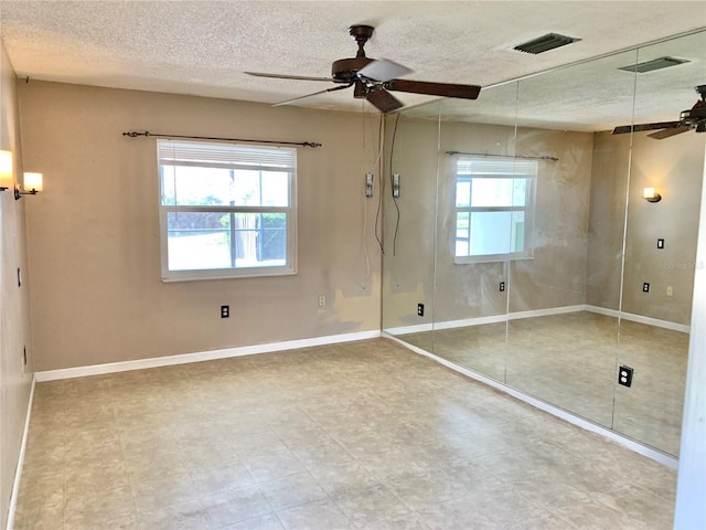 unfurnished bedroom with a closet, multiple windows, and a textured ceiling