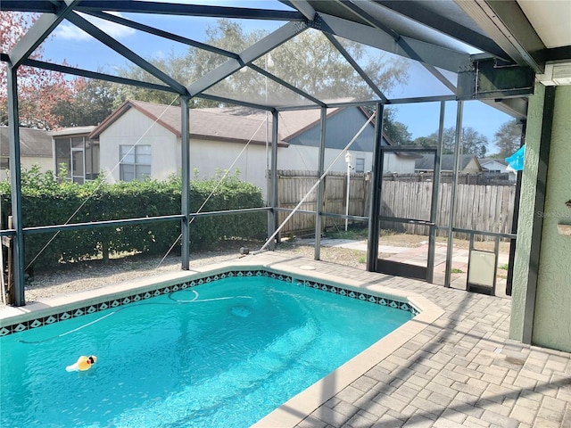 view of swimming pool featuring a lanai and a patio