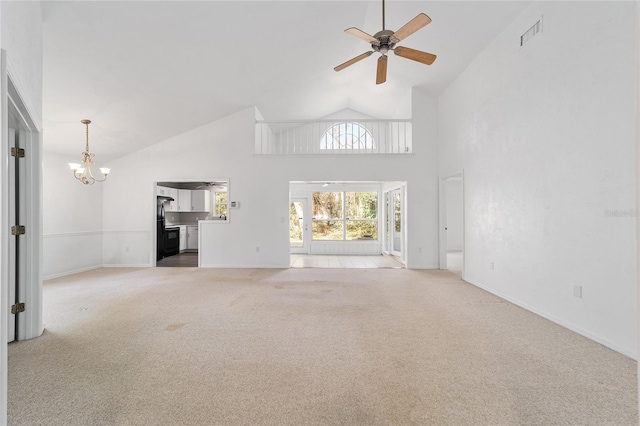 unfurnished living room with light colored carpet, high vaulted ceiling, and ceiling fan with notable chandelier