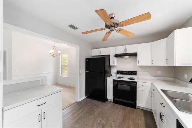 kitchen with pendant lighting, white cabinetry, sink, black appliances, and dark wood-type flooring