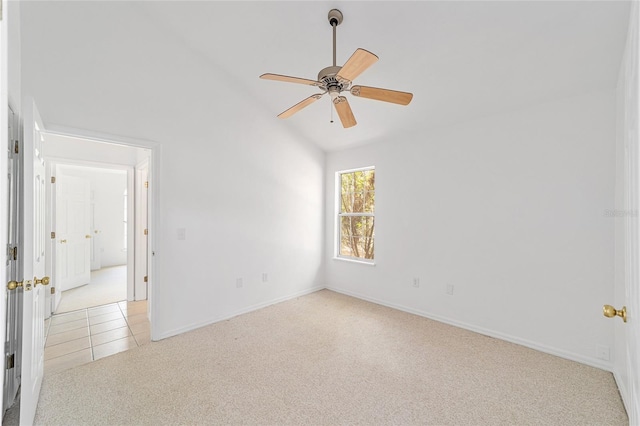 empty room with ceiling fan, vaulted ceiling, and light carpet