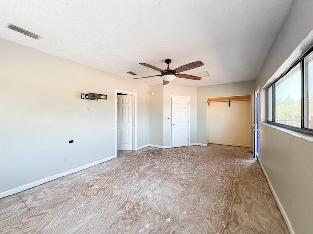 unfurnished bedroom with ceiling fan, a textured ceiling, and a closet