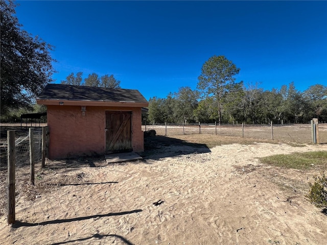 view of yard featuring a rural view and a storage shed