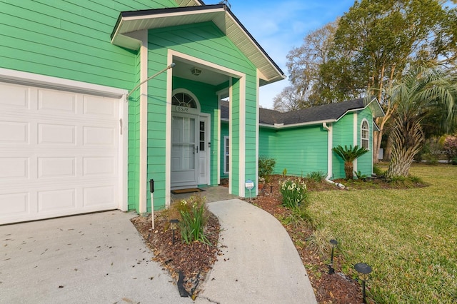 entrance to property with a garage and a lawn