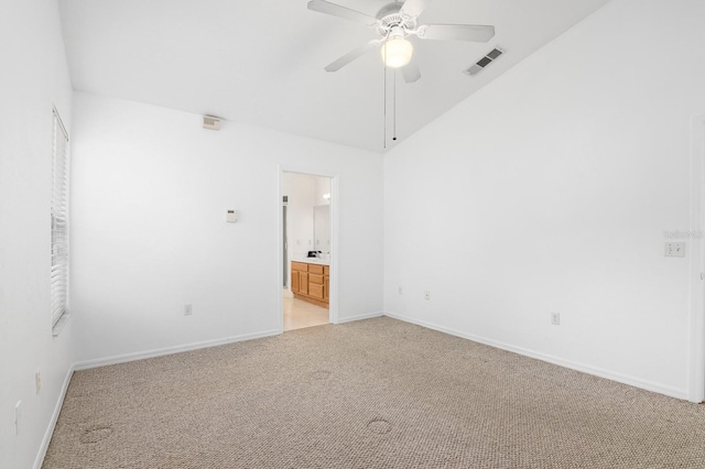 unfurnished room with light colored carpet, a ceiling fan, baseboards, vaulted ceiling, and visible vents