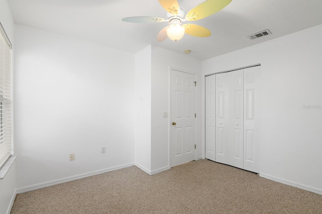 unfurnished bedroom with a closet, carpet, visible vents, and baseboards