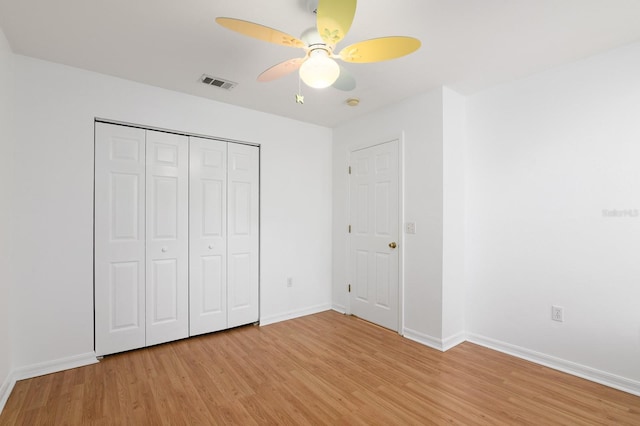 unfurnished bedroom with a ceiling fan, baseboards, visible vents, light wood-style floors, and a closet