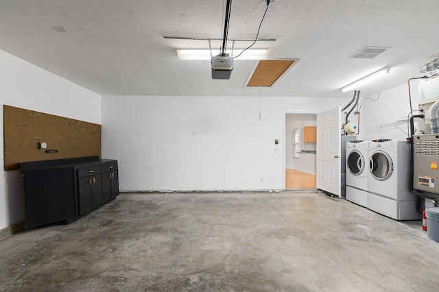 garage with washing machine and clothes dryer and a garage door opener