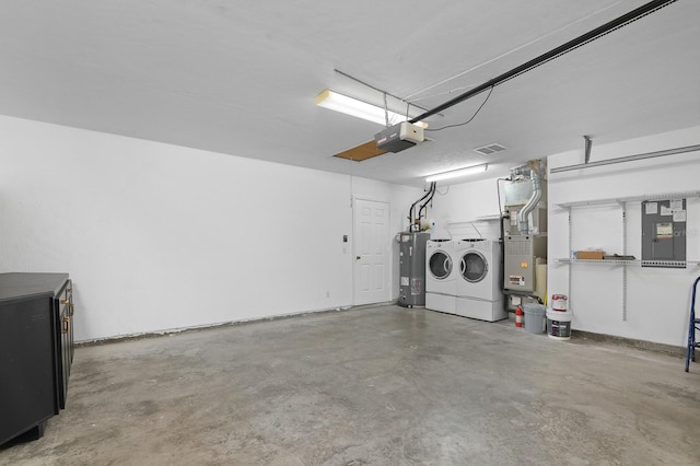 garage with washing machine and dryer, visible vents, water heater, a garage door opener, and heating unit