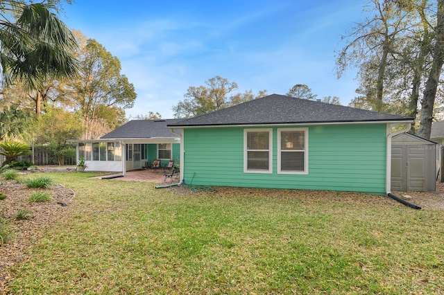 back of house with an outbuilding, a yard, a sunroom, fence, and a shed