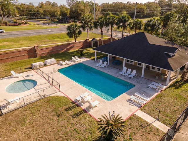 pool featuring a yard, a patio area, and fence