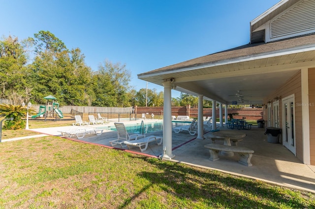 exterior space with playground community, fence, and a fenced in pool