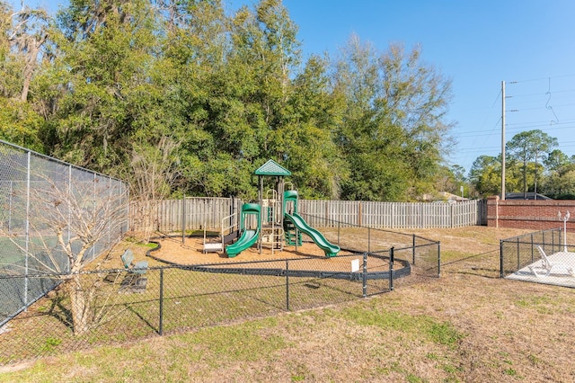 communal playground featuring a yard and fence