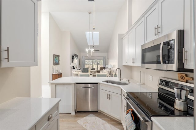 kitchen with pendant lighting, white cabinetry, appliances with stainless steel finishes, and sink