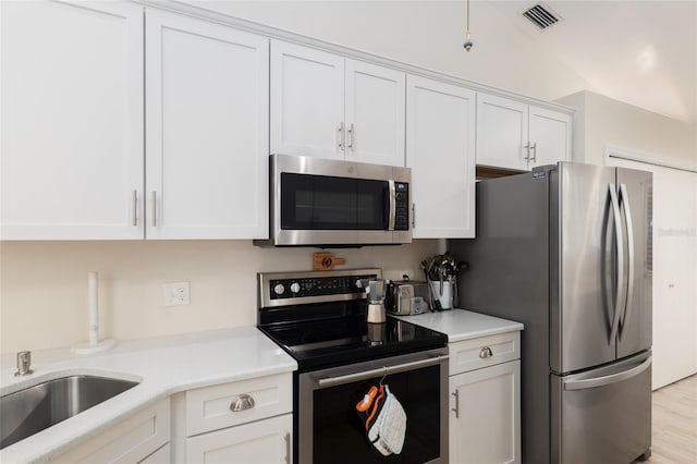 kitchen featuring stainless steel appliances, white cabinetry, and light hardwood / wood-style floors