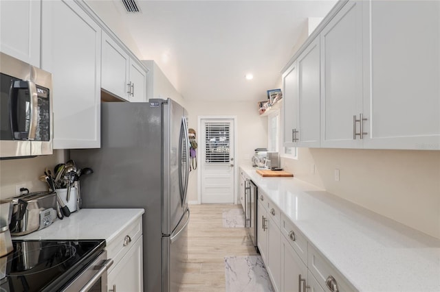 kitchen featuring white cabinetry, stainless steel appliances, and light stone countertops