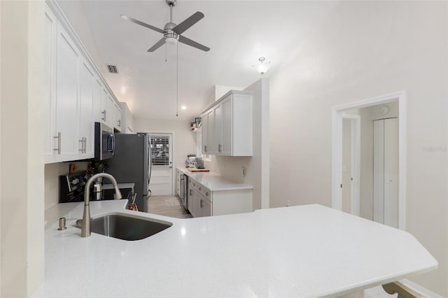 kitchen featuring sink, ceiling fan, white cabinetry, stainless steel appliances, and kitchen peninsula