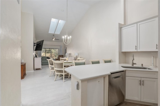 kitchen featuring sink, stainless steel dishwasher, kitchen peninsula, pendant lighting, and white cabinets