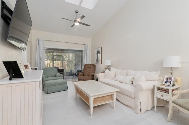 living room with a skylight, high vaulted ceiling, and ceiling fan