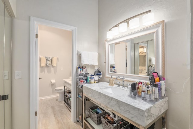 bathroom with hardwood / wood-style flooring, toilet, and sink