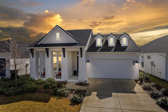 view of front of house with board and batten siding, concrete driveway, a shingled roof, and an attached garage