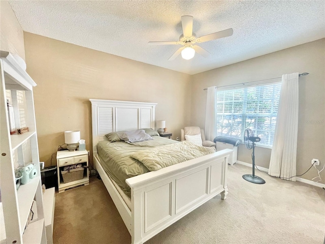 carpeted bedroom featuring ceiling fan and a textured ceiling