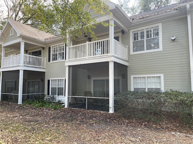 back of property featuring a balcony and a sunroom