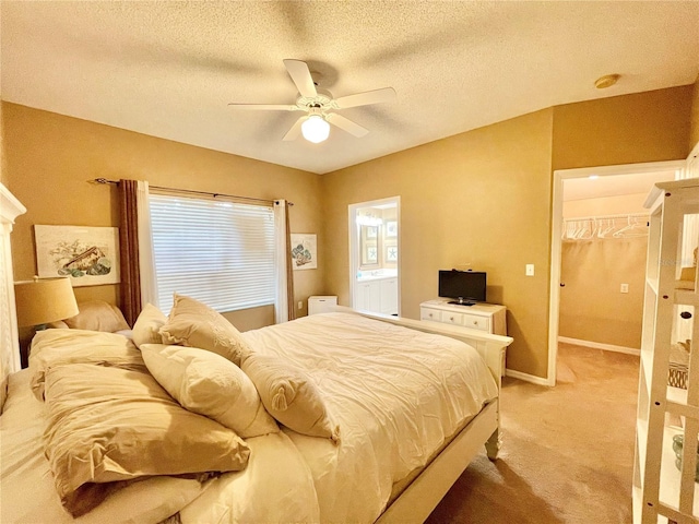 10000 SW 52nd Ave Unit 103, Gainesville, FL 32608 - bedroom featuring baseboards, a ceiling fan, a textured ceiling, a walk in closet, and light carpet