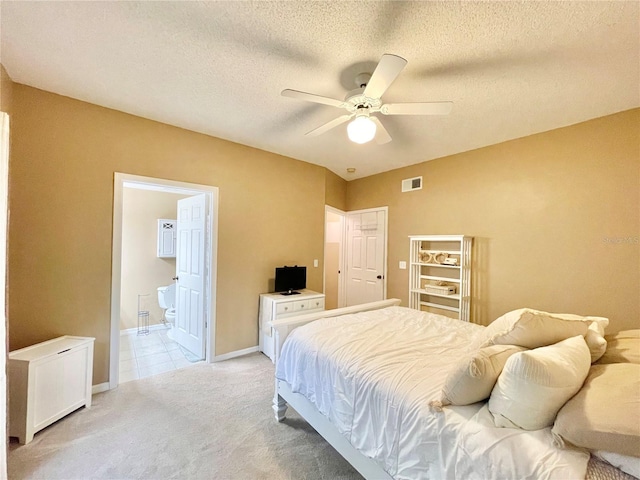 10000 SW 52nd Ave Unit 103, Gainesville, FL 32608 - bedroom with visible vents, baseboards, ensuite bathroom, a textured ceiling, and light carpet