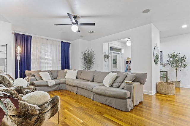 living room with ceiling fan and light hardwood / wood-style flooring