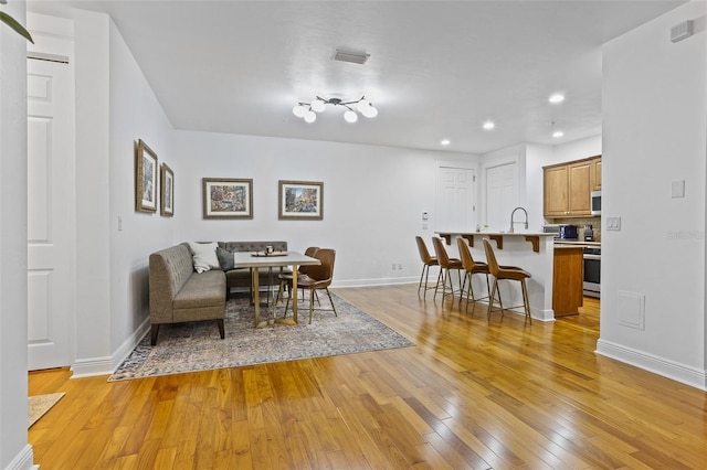 dining room featuring sink and light hardwood / wood-style floors