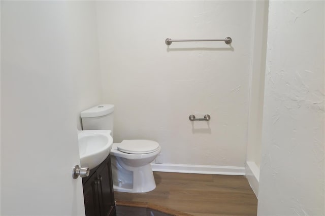 bathroom with vanity, toilet, and hardwood / wood-style floors