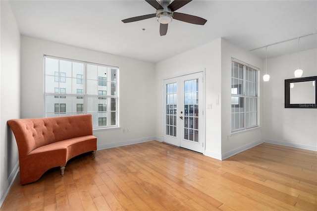 sitting room featuring light hardwood / wood-style flooring, ceiling fan, and french doors