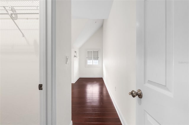 corridor with dark wood-type flooring and lofted ceiling