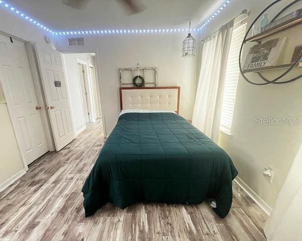 11607 NW 18th Pl, Gainesville, FL 32606 - bedroom featuring wood finished floors, visible vents, and baseboards