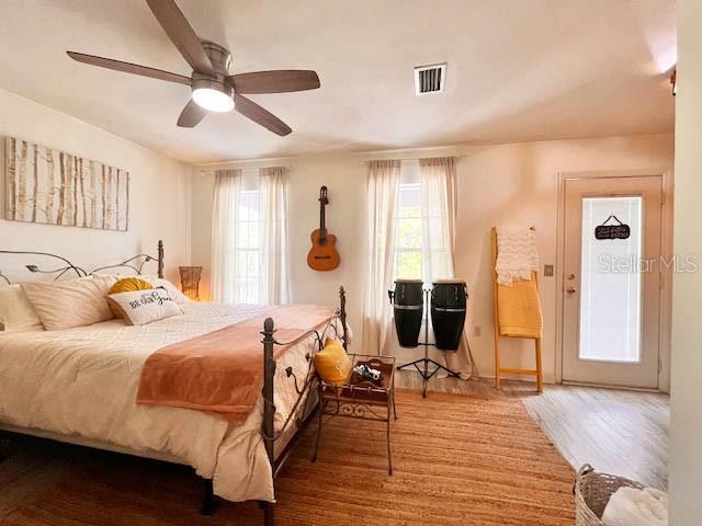 11607 NW 18th Pl, Gainesville, FL 32606 - bedroom with wood finished floors, visible vents, and ceiling fan